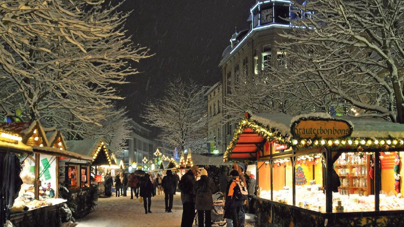 Weihnachtsmarkt in Brühl zur blauen Stunde – beleuchtete Buden und verschneite Bäume